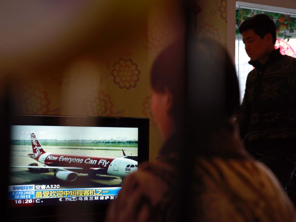 Relatives of passengers onboard the Malaysia Airlines Flight 370 that went missing on March 8, 2014, watch TV news about missing AirAsia flight QZ8501, during their year-end gathering at a house in Beijing, China Sunday, Dec. 28, 2014. 