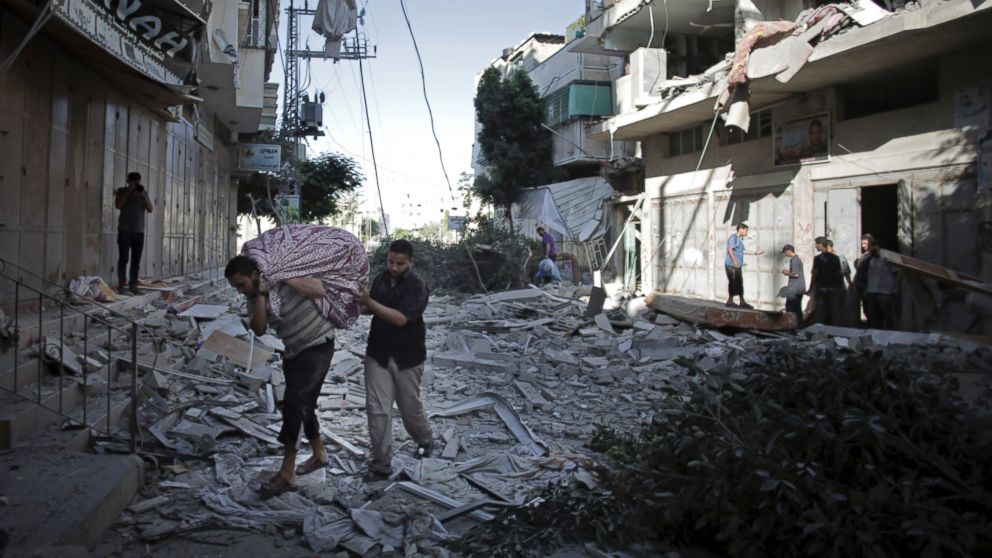 PHOTO: Palestinians salvage what they can of their belongings from the rubble of their destroyed house following an early morning Israeli missile strike in Gaza City, July 16, 2014.