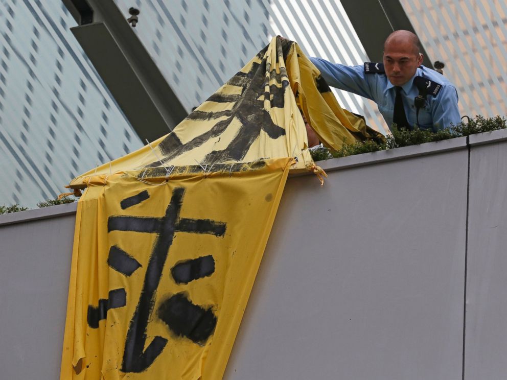 PHOTO: A police officer removes a banner on the bridge at the occupied area outside government headquarters in Hong Kong, Dec. 11, 2014.