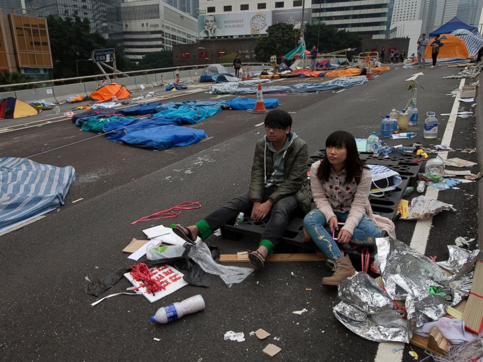 PHOTO: A couple sit at a main road before police clearing barricades and tents outside government headquarters in Hong Kong, Dec. 11, 2014.