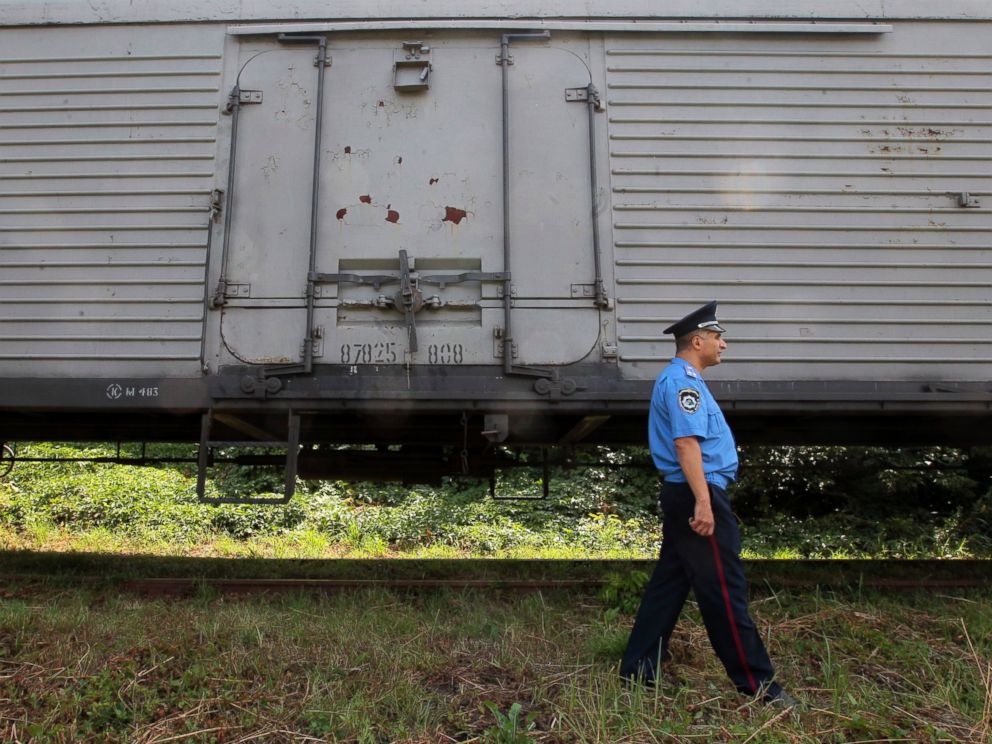 PHOTO: A police officer walks past a refrigerated train loaded with bodies of the passengers of Malaysian Airlines flight MH17 at Kharkiv railway station, Ukraine, July 22, 2014.