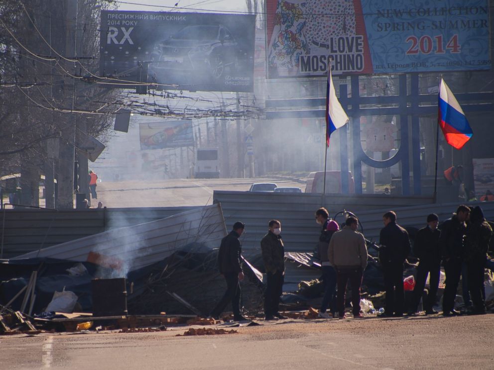 PHOTO: Pro-Russian activists gather behind a barricade with Russian flags in front an entrance of the Ukrainian regional office of the Security Service in Luhansk, 20 mile west of the Russian border, in Ukraine, April 8, 2014.