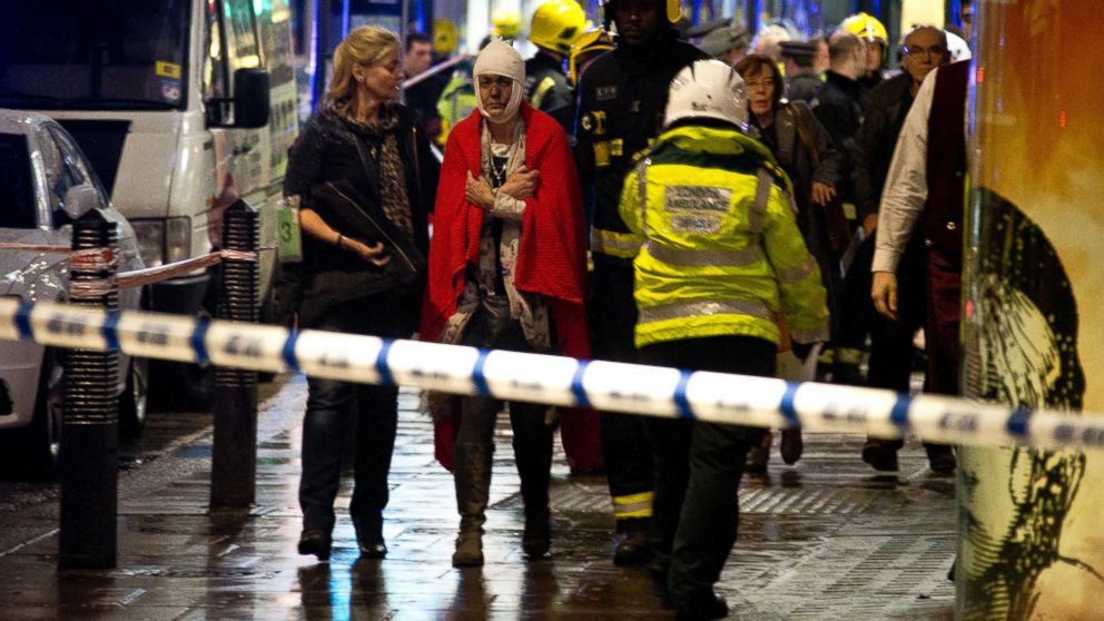 PHOTO:A woman stands bandaged and wearing a blanket given by emergency services following an incident at the Apollo Theatre, Dec. 19, 2013, with police saying there were "a number" of casualties.