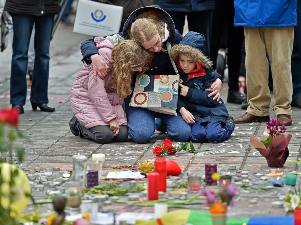 PHOTO: A woman and children sit and mourn for the victims of the bombings at the Place de la Bourse in the center of Brussels, March 23, 2016.