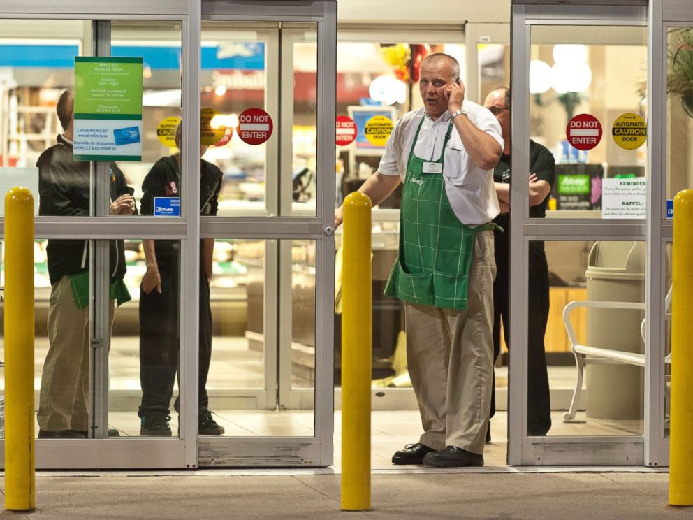 PHOTO: Employees of a grocery store lock down their store in Moncton, New Brunswick, June 4, 2014 following a shooting.