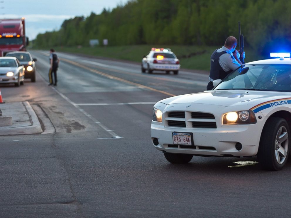 PHOTO: Royal Canadian Mounted Police officers use their vehicles to create a keep a perimeter in Moncton, New Brunswick, June 4, 2014, following a shooting.