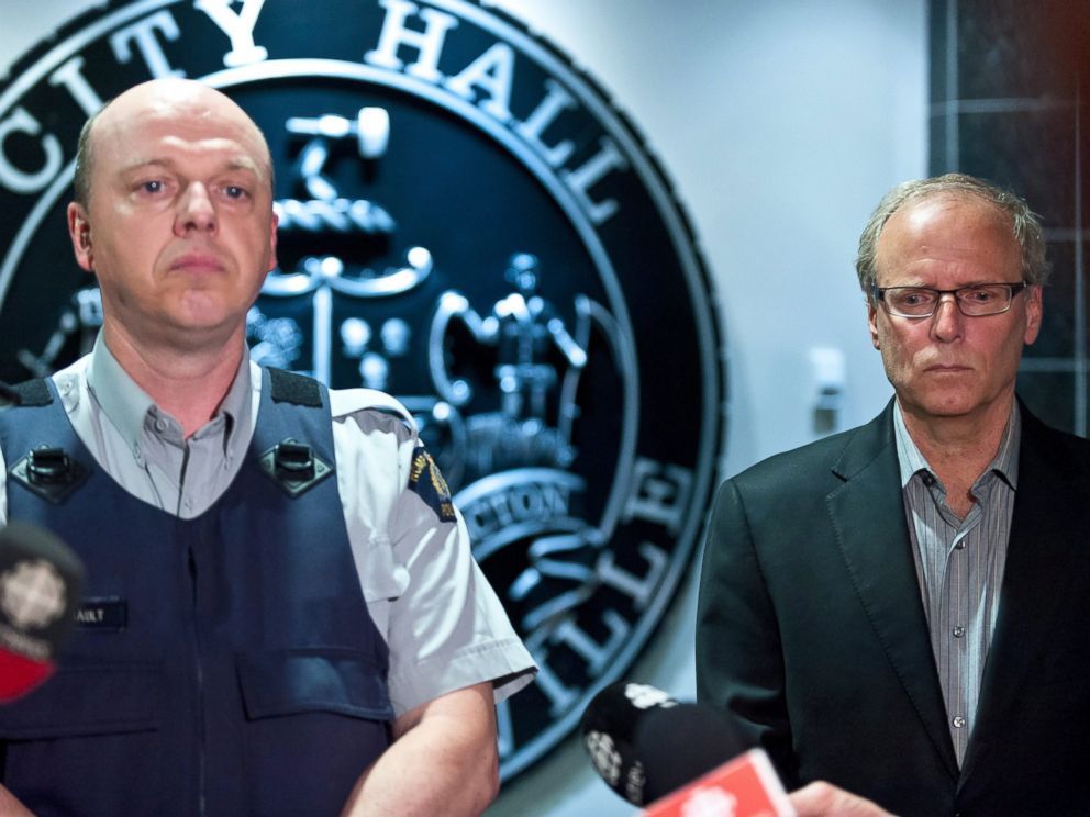 PHOTO: Royal Canadian Mounted Police officer Damien Theriault and Mayor George LeBlanc pause to collect themselves before addressing the media during a late night news conference at City Hall in Moncton, New Brunswick, June 4, 2014.