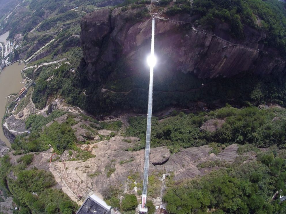 PHOTO: Sunlight reflects off a glass-bottomed suspension bridge as seen from the air in a scenic zone in Pingjiang county in southern Chinas Hunan province, Sept. 24, 2015.