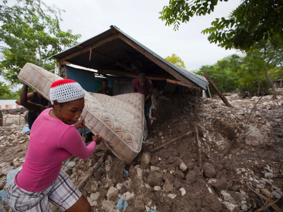 PHOTO: Residents salvage a mattress from a home partially submerged in mud from a mudslide triggered by Tropical Storm Erika, Aug. 29, 2015, in Montrouis, Haiti.