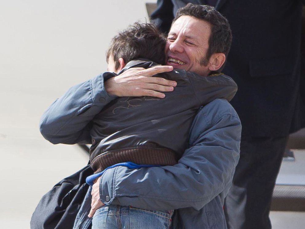 PHOTO: Spanish reporter Javier Espinosa hugs as his son Yerai upon his arrival at the military airport of Torrejon in Madrid, Sunday, March 30, 2014.