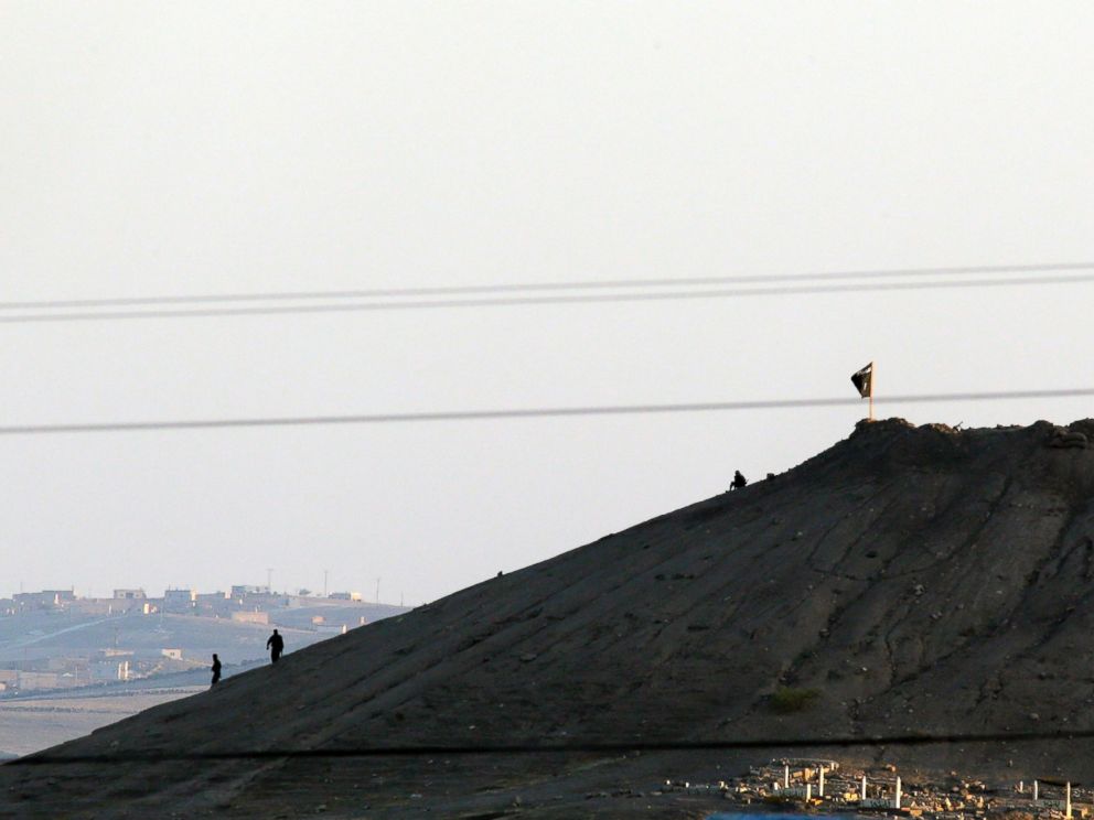 PHOTO: Militants with the Islamic State group are seen after placing their groups flag on a hilltop at the eastern side of the town of Kobani, Syria, Oct. 6, 2014.