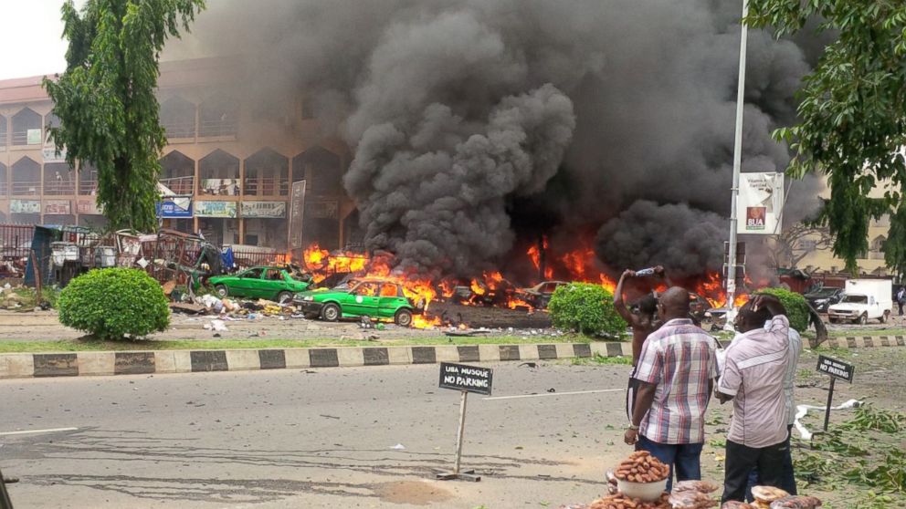 PHOTO: People watch as smoke fills the sky after an explosion at a shopping mall, June 25, 2014, in Abuja, Nigeria. 