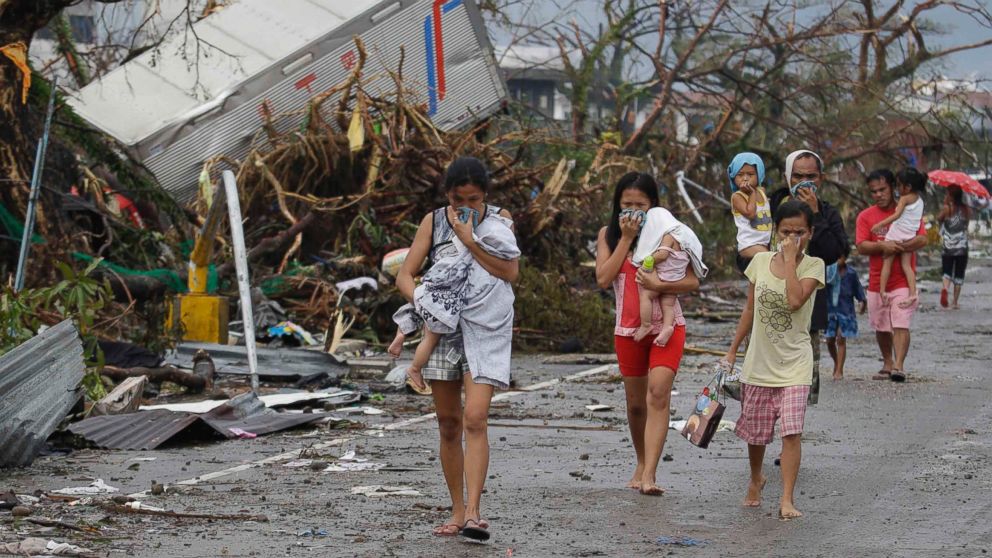 PHOTO: Residents cover their nose from the smell of dead bodies in Tacloban city, Leyte province central Philippines on Sunday, Nov. 10, 2013.