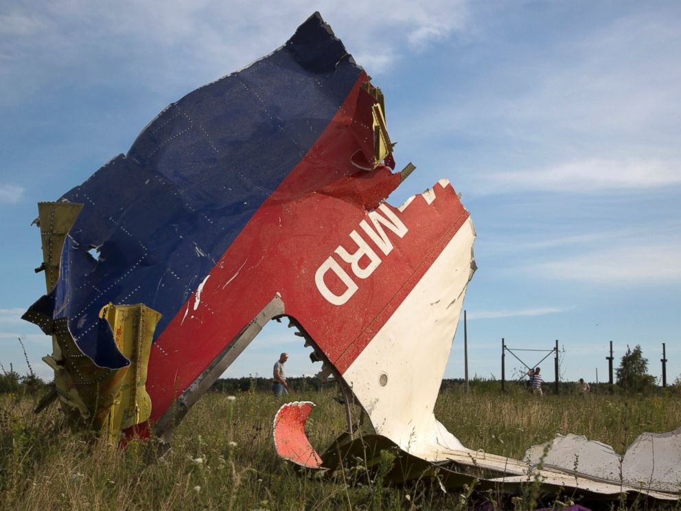 PHOTO: A man walks past a piece of the crashed Malaysia Airlines Flight 17 near the village of Hrabove, eastern Ukraine, July 21, 2014.