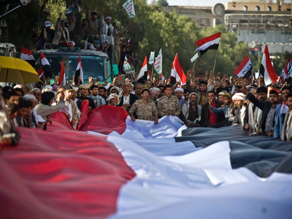 PHOTO: Houthi Shiite Yemenis hold carry a large representation of the national flag during a celebration marking the fourth anniversary of the revolution in Sanaa, Yemen, Feb. 11, 2015.