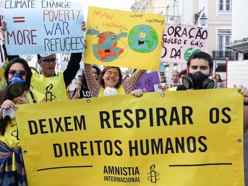 PHOTO: Protesters hold a sign with the text Let humans have the right to breathe, during a World Climate March in Lisbon, Portugal, April 29, 2017.