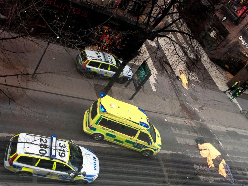PHOTO: An ambulance stands near covered bodies at the scene where a truck crashed into the Ahlens department store at Drottninggatan in central Stockholm, April 7, 2017.