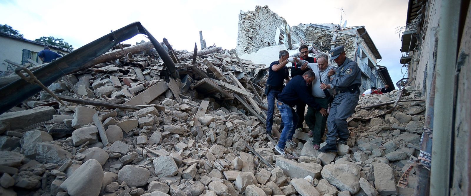 PHOTO: Residents and rescuers help a man among the rubble after a strong earthquake hit Amatrice on August 24, 2016