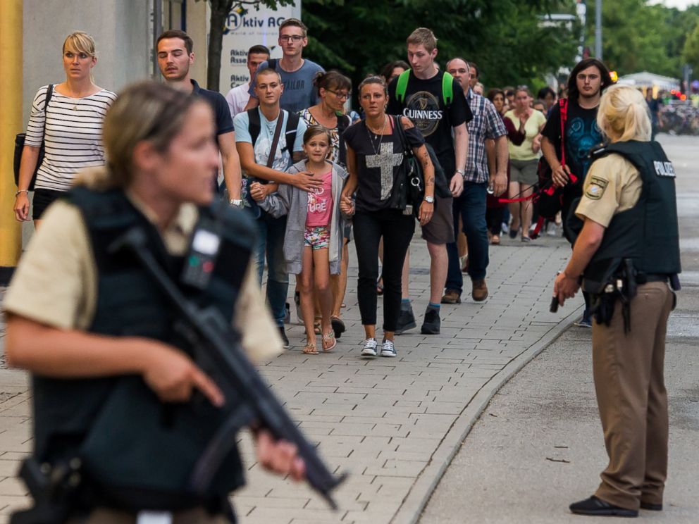 PHOTO: Police officers escort people from inside the shopping center as they respond to a shooting at the Olympia Einkaufzentrum on July 22, 2016 in Munich.