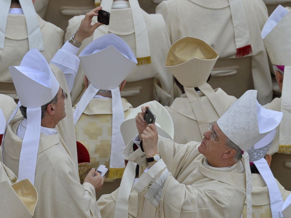 PHOTO: Bishops take pictures before the canonization mass of Popes John XXIII and John Paul II on St Peters at the Vatican on April 27, 2014.