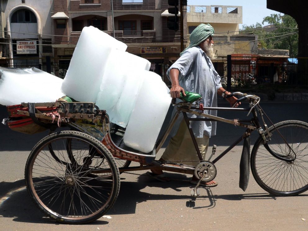 PHOTO: An Indian worker uses a ricksahw to transport ice from an ice factory in Amritsar on May 27, 2015.