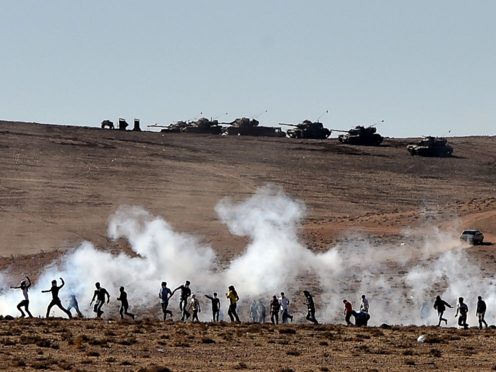 PHOTO: Kurdish people throw stones at Turkish armored vehicles near the Syrian town known as Kobane by the Kurds, in the southeastern town of Suruc, Sanliurfa province, Turkey, Oct. 7, 2014.