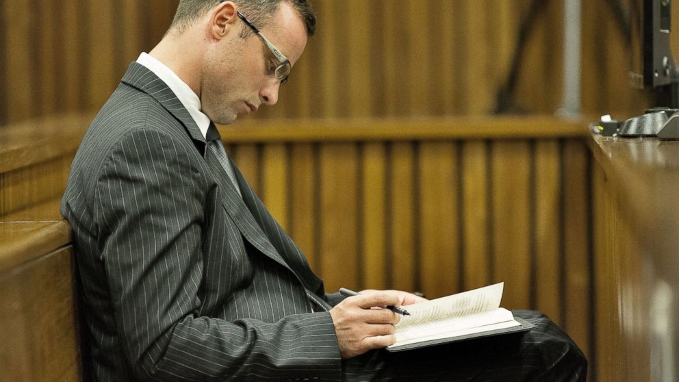 PHOTO :Oscar Pistorius spent part of his time in court during his murder trial underlining passages in a religious book or fingering rosary beads.