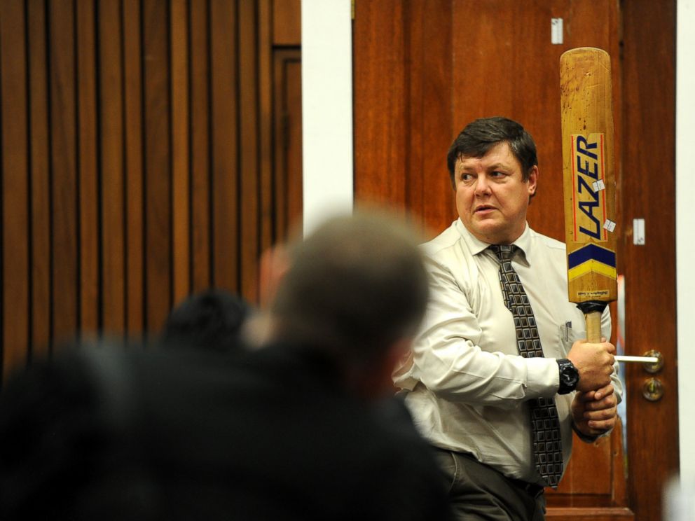 PHOTO: Forensic investigator Johannes Vermeulen takes part in the reconstruction of hitting a door with a cricket bat during the trial of Oscar Pistorius in Pretoria, South Africa on March 12, 2014.