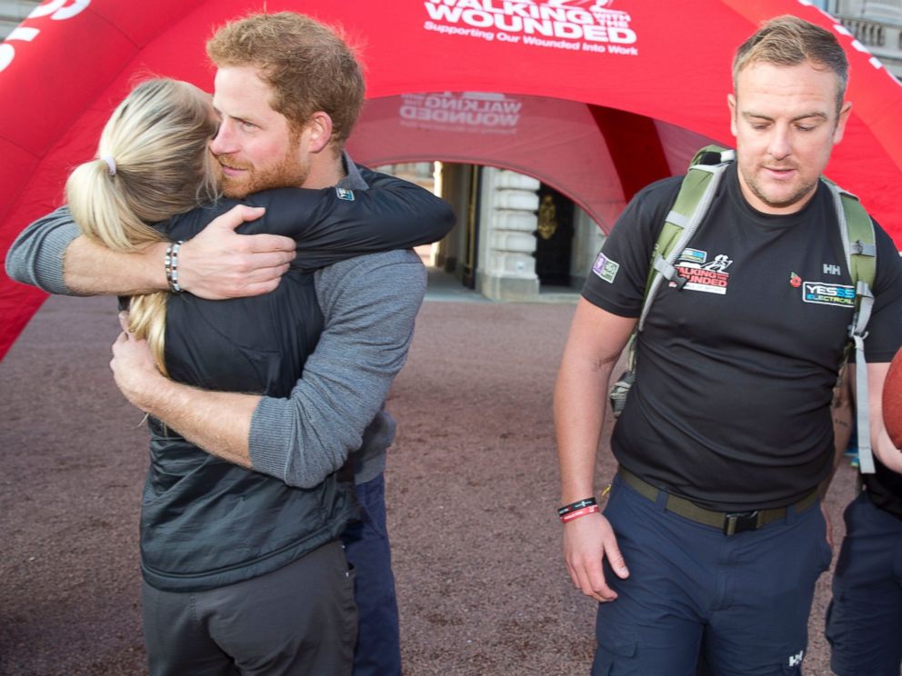 PHOTO: Prince Harry hugs Kirsty Ennis, a helicopter door gunner and Afghan veteran as he meets with members of the Walking With The Wounded team at Buckingham Palace, Nov. 1, 2015 in London.