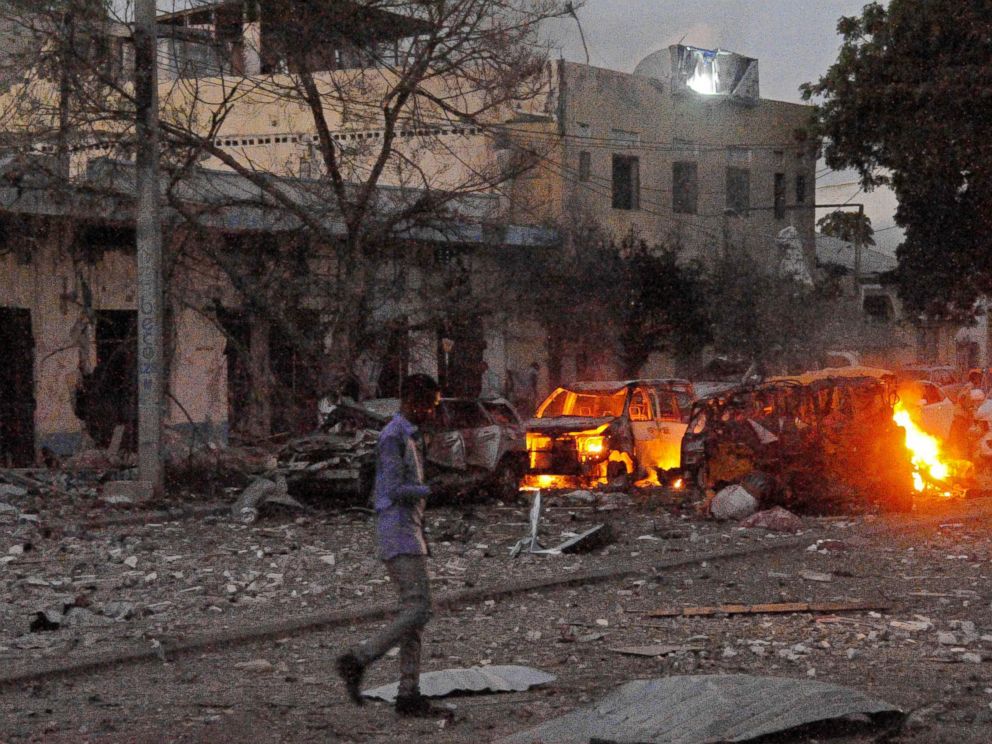 PHOTO: A man walks past the scene after a car bomb exploded, June 1, 2016, outside a Mogadishu hotel that houses several MPs, killing several people, and followed by a gun battle.