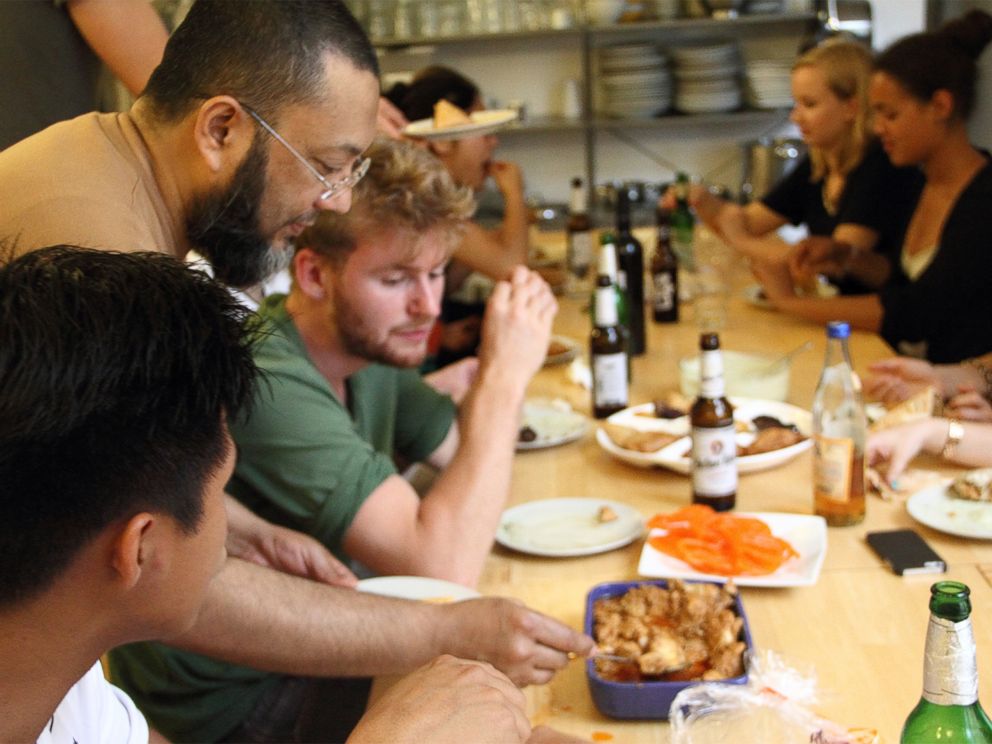 PHOTO: Refugees and Germans sharing a meal at a community kitchen event organized by Ueber den Tellerrand kochen -