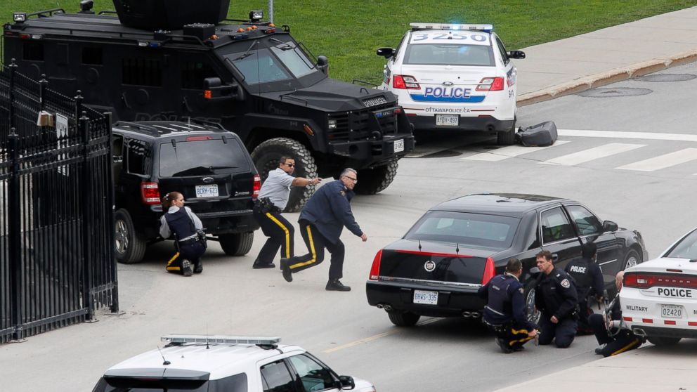 PHOTO: Police officers take cover near Parliament Hilll following a shooting incident in Ottawa, Oct. 22, 2014. 