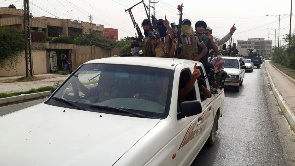 PHOTO: Fighters of the Islamic State of Iraq and the Levant (ISIL) celebrate on vehicles taken from Iraqi security forces, at a street in city of Mosul, June 12, 2014.