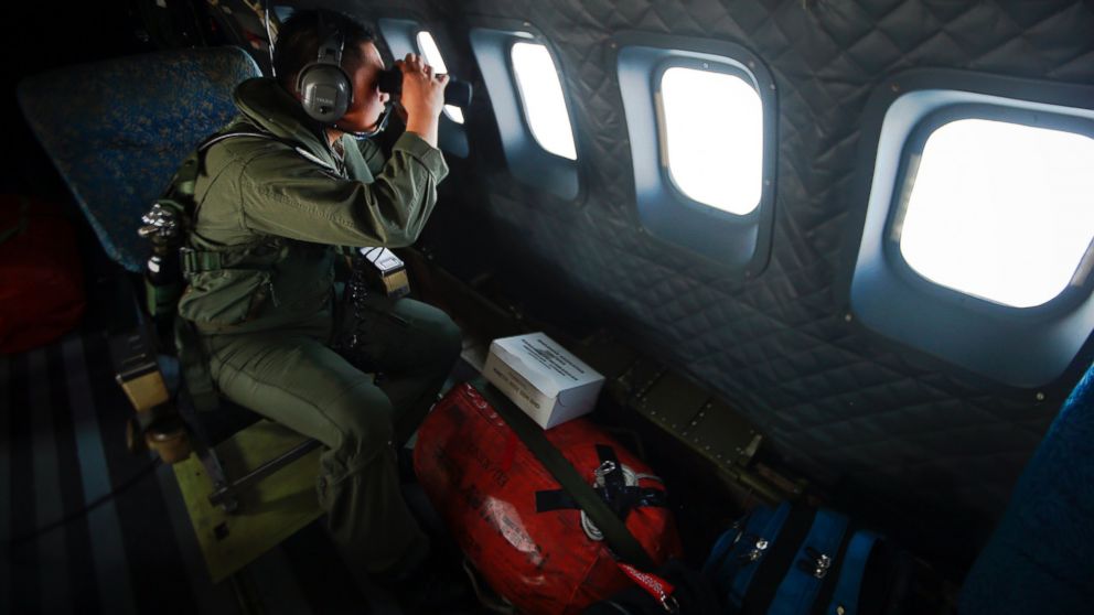PHOTO: A crew member from the Royal Malaysian Air Force uses binoculars onboard a Malaysian Air Force CN235 aircraft during a Search and Rescue (SAR) operation to find the missing Malaysia Airlines flight MH370, in the Straits of Malacca March 13, 2014.