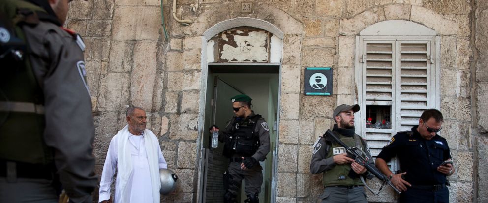 Israeli border police officers stand guard as Palestinians gather for prayer at the Lions Gate, following an appeal from clerics for Muslims to pray in the streets instead of the Al-Aqsa Mosque compound, in Jerusalems Old City, Wednesday, July 19,