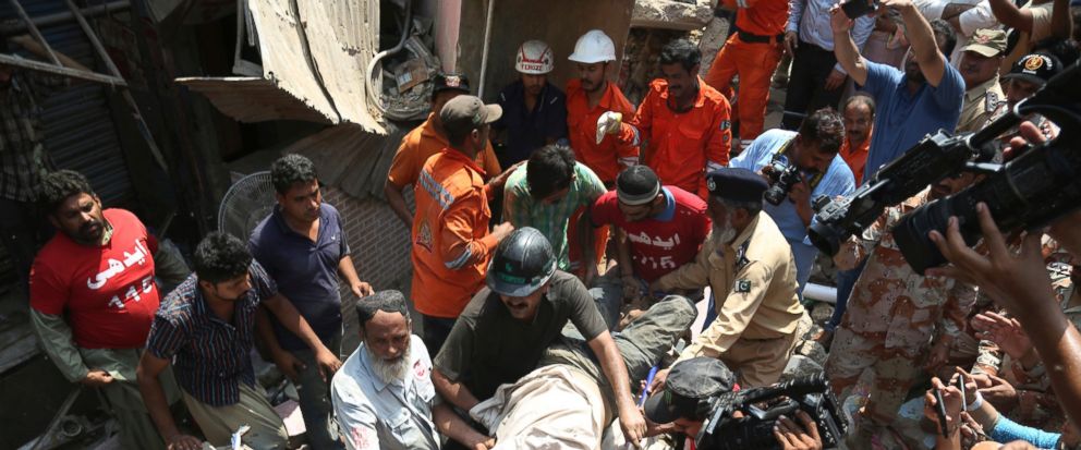 Pakistani volunteers carry an injured person rescued from a collapsed apartment in Karachi, Pakistan, Tuesday, July 18, 2017. A dilapidated, three-story building in a poorer neighborhood of Pakistans sprawling port city of Karachi collapsed as the r