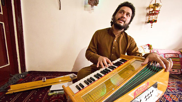 PHOTO: 23-year old Naweed Forugh, a former winner of Afghanistans version of American Idol, plays the harmonia, a traditional Afghan musical instrument, in his living room. After nearly losing his life to an unknown gunman, Forugh is too afraid to leave