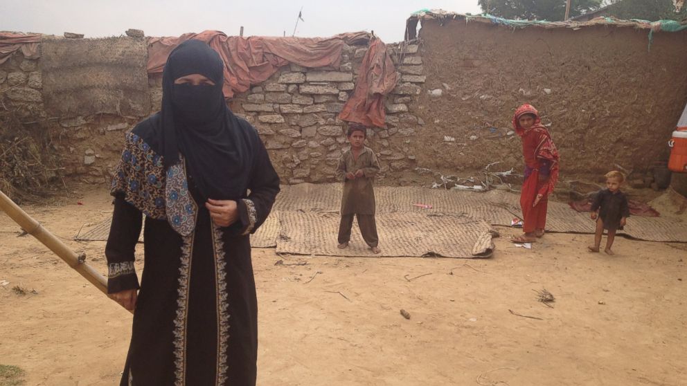 PHOTO: Chand Bibi at school with some of her students in the background. Her school has no roof, a limited number of notebooks and a tiny white board, but she thinks it provides some service for children who would otherwise have no school to go to.