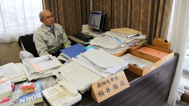 PHOTO: Minamisoma, Japan mayor Katsunobu Sakurai looks out the window of his office, one year after Japans earthquake and tsunami.