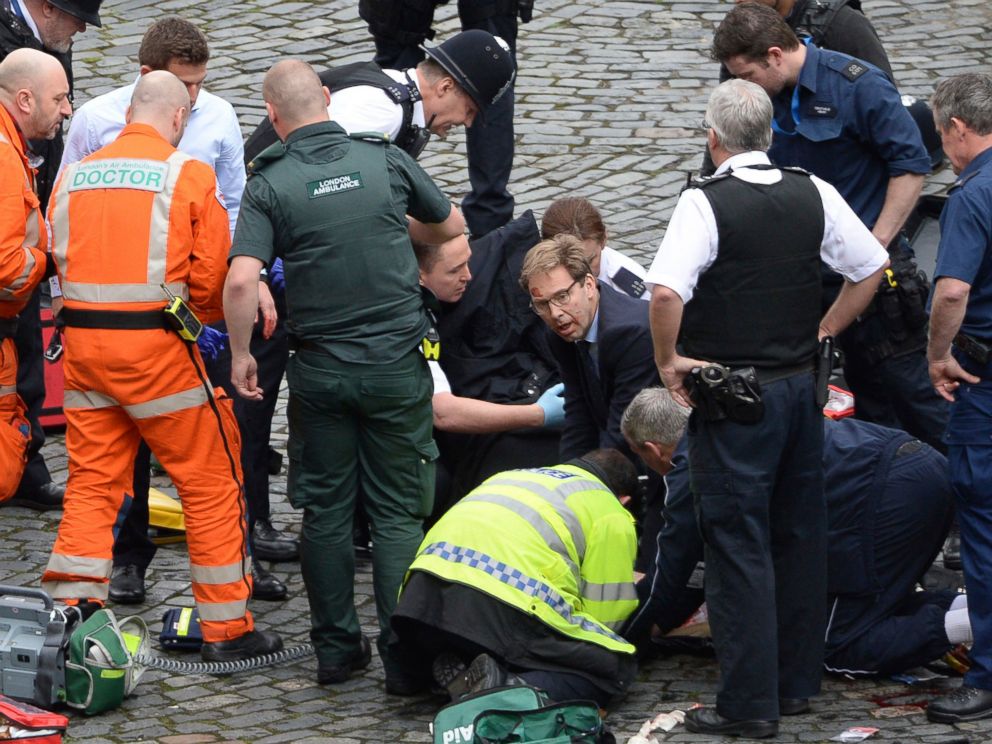 PHOTO: Conservative Member of Parliament Tobias Ellwood, center, helps emergency services attend to an injured person outside the Houses of Parliament, London, March 22, 2017.