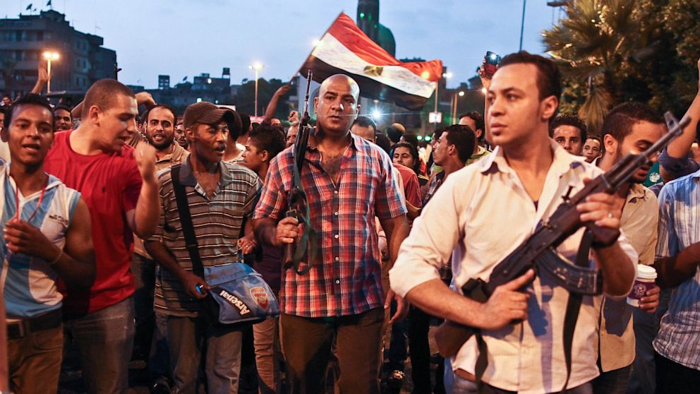 PHOTO: Plainclothes policemen walk with protesters opposed to Egyptian President Mohammed Morsi at the site of clashes with opposing protesters in the Kit Kat neighborhood of Giza, Egypt, Tuesday, July 2, 2013.