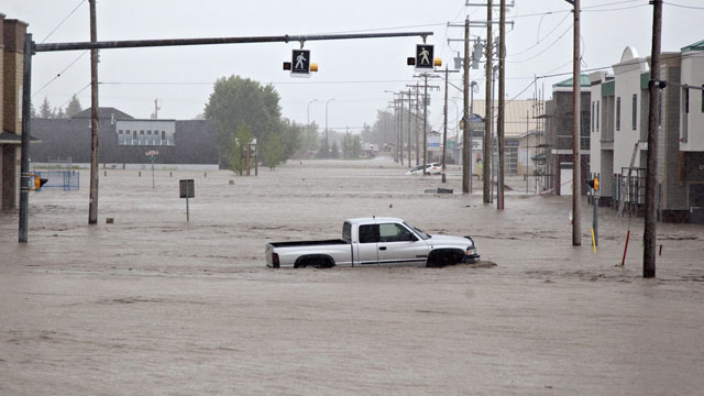 PHOTO: A truck sits submerged in the flood waters near High River, Alta. on Thursday, June 20, 2013 after the Highwood River overflowed. Calgary officials say as many as 100,000 people could be forced from their homes due to heavy flooding in Canada.