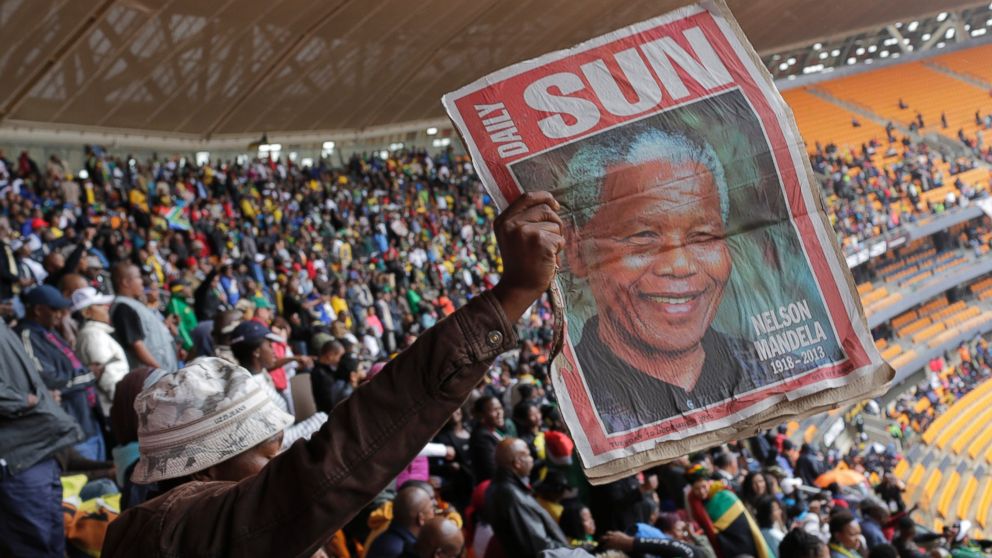 PHOTO: A man holds up an image of former South African president Nelson Mandela ahead of a memorial service at the FNB Stadium in Soweto, near Johannesburg, South Africa, Tuesday Dec. 10, 2013.