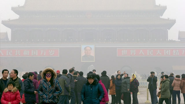 PHOTO: Visitors stand on Tiananmen Square across from a portrait of former Chinese leader Mao Zedong in thick haze in Beijing, China, Jan. 29, 2013.
