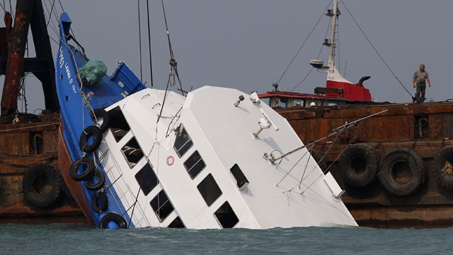 PHOTO: Officials check on a half submerged boat after it collided Monday night near Lamma Island, off the southwestern coast of Hong Kong Island Tuesday Oct. 2, 2012.