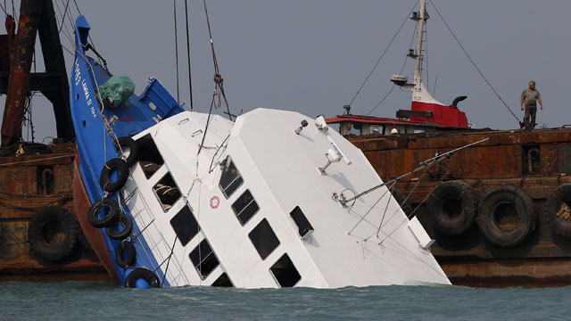 PHOTO: Officials check on a half submerged boat after it collided Monday night near Lamma Island, off the southwestern coast of Hong Kong Island Tuesday Oct. 2, 2012.