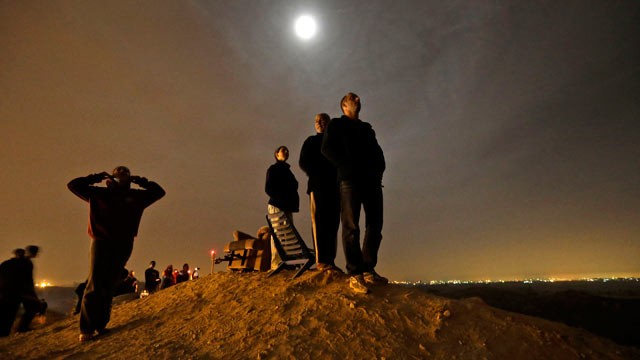 PHOTO: The moon illuminates Israelis standing on a hill at the Israeli town of Sderot, overlooking the Gaza Strip, as they watch a missile, not seen, fired by Palestinian militants from inside Gaza towards southern Israel, Nov. 21, 2012, shortly before a 