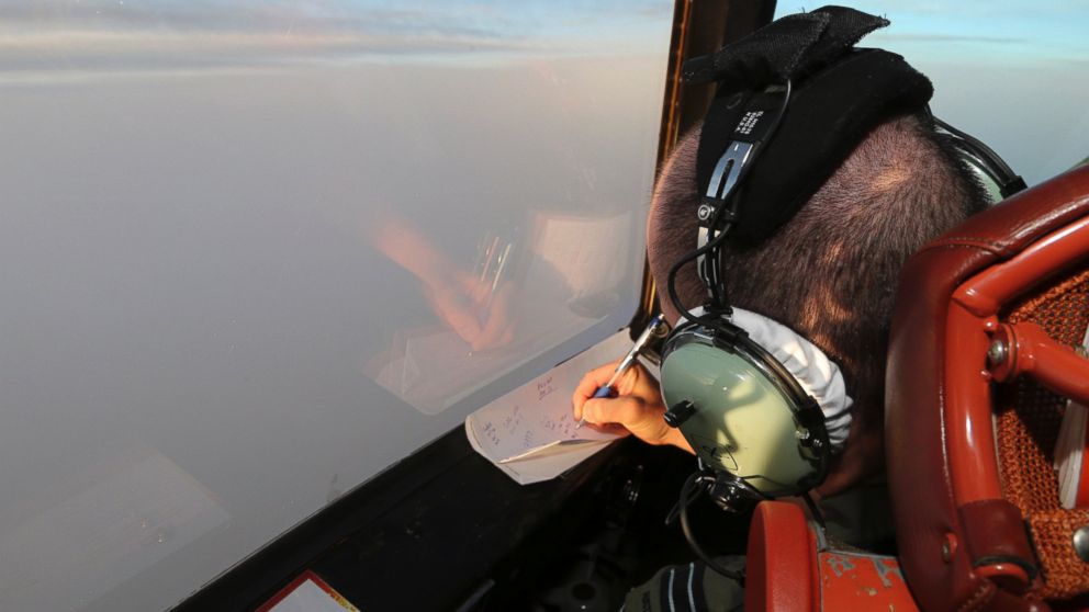 PHOTO: Flight Lt. Jason Nichols on board a Royal Australian Air Force AP-3C Orion, takes notes as they search for the missing Malaysia Airlines Flight MH370 in southern Indian Ocean, Australia, Saturday, March 22, 2014.