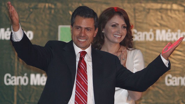 PHOTO: Presidential candidate Enrique Pena Nieto gestures to supporters next to his wife Angelica Rivera at his party's headquarters in Mexico City, early Monday, July 2, 2012.