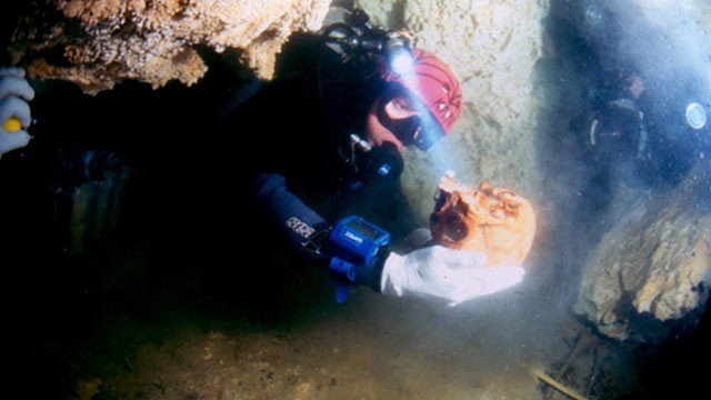 PHOTO: A diver holds a skull belonging to a woman, known as La Mujer de las Palmas, who lived between 10,000 and 12,000 years ago, in Tulum, Mexico.